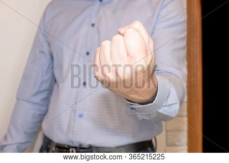 The Man Inside The Apartment Shows A Clenched Fist.