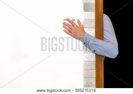 Male Hand Out Of The Darkness Reaches For The Light Switch.