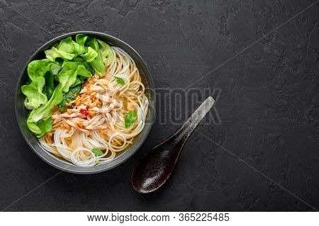 Guay Tiew Gai Cheek Or Thai Chicken Noodle Soup In Black Bowl On Dark Slate Backdrop. Guay Tiew Gai