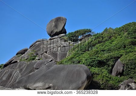 Rock Sail In Thailand. Ancient Cliffs, In Some Places Covered With Green Shrubs. Against The Blue Sk