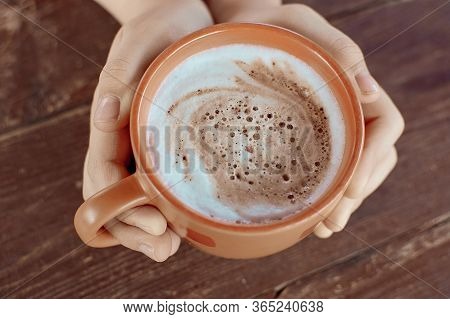 A Cup Of Hot Flavored Cocoa In The Hands. Close-up Photo. Beautiful Milk Froth