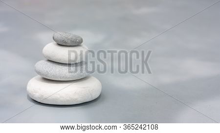 Four Grey Roundstones On Clear Gray Background. Spa Stones, Zen Like Concept. Pastel Colors
