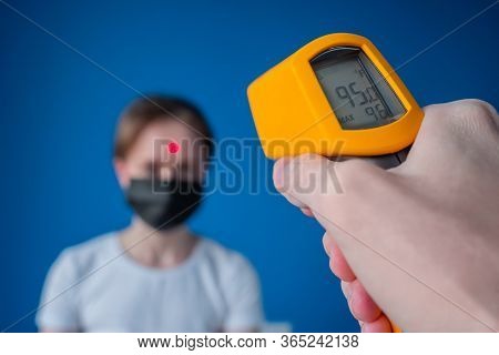 Measurement, Healthcare, Infection, Coronavirus Concept. Man Hand Holding Yellow Pyrometer And Measu