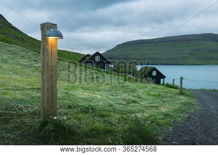 Picturesque view of tradicional faroese grass-covered houses in the village Bour at evening time. Vagar island, Faroe Islands, Denmark.