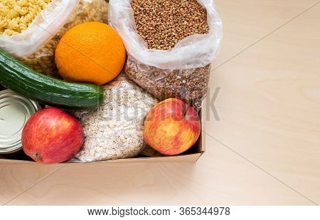 Food Delivery Box On The Wood Background For People During House Isolation With Vegetable Oil, Cucum