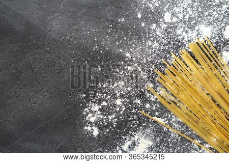 Yellow Long Spaghetti On Grey Background With Flour. Yellow Italian Pasta. Long Spaghetti. Raw Spagh