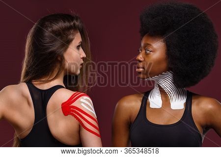 Kinesiology Taping. Two Young Female Athletes On Red Background With Kinesiology Tape On Neck, Shoul