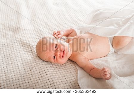 Newborn On The Bed. Crying, Screaming Baby Close Up And Copy Space. Baby Smile And Colic In Newborns