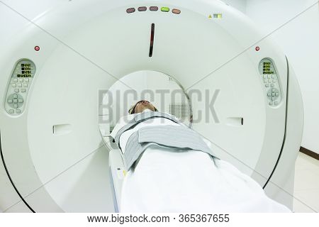 Patients Screening On Ct Scanner. Man Undergoing Ct Scan While Doctor\'s Using Computers. Examining 
