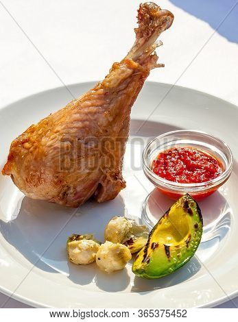 A White Plate Topped With Chicken Leg