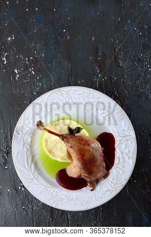 Duck Leg With Cherry Sauce And Mashed Potatoes.served With Green Butter.