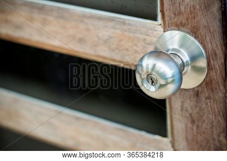 Door With Grill, Stainless Door Knob Or Handle On Wooden Door In Beautiful Lighting.a Handle On A Do