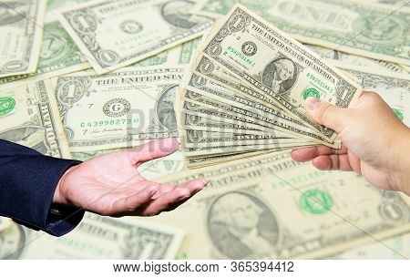 Hand Hold Many Dollar Banknotes And Another One Act Receive That Money With Dollar Background. Corru