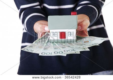 Frau holding PLN (polnische Zloty) Rechnungen und Haus Modell over White - Immobilien-Darlehen-Konzept