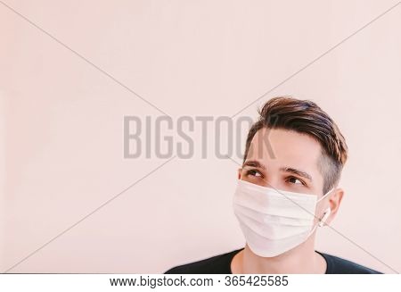 Young Happy Sports Man In Protective Face Mask Look Up At Background With Copy Space. Confident Man 