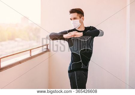Happy Young Sports Man In Protective Mask Doing Yoga Exercises For Strecthing Muscles During Covid-1