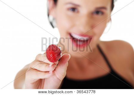 Giovane donna felice con fragola. Focalizzata su strowberry.