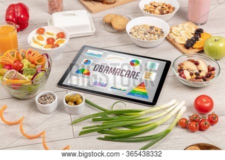 Organic food and tablet pc showing OBAMACARE inscription, healthy nutrition composition