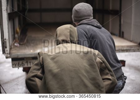 Loaders Are Loading Metal Into A Lorry. Transportation Of Heavy Industrial Products. Men Do Their Jo