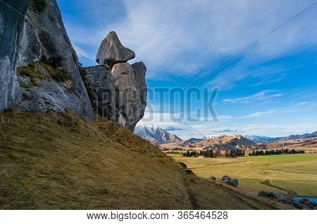 Mountain Landscape With Snow Capped Mountains And Green Hills With Rocks And Boulders. Countryside L