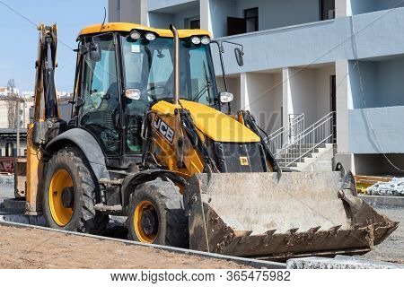 Kharkiv, Ukraine, March 29, 2020: Excavator Jcb Parked Outside. The Dirty Yellow Tractor At The Cons