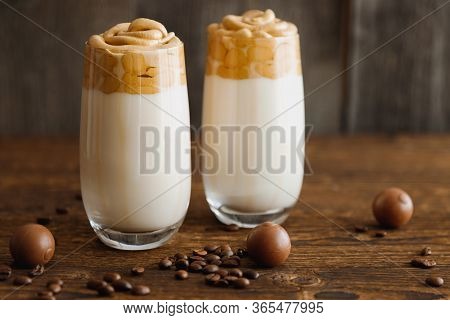Two Glasses, Glasses, Cups With Cold Dalgon Milk And Coffee Drink On A Wooden Background With Chocol