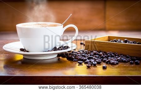 Coffee Cup And Coffee Beans On Table With Smoke