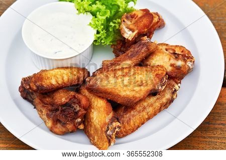 A Plate Of Chicken Wings On A Table