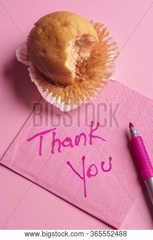 Bitten Muffin On A Pink Napkin. Paper Napkin With 