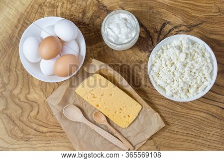 Rustic Products On A Textured Wooden Table: Cottage Cheese, Eggs, Sour Cream And Cheese. Healthy Foo
