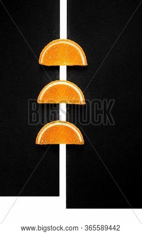 Orange Slices Of Marmalade On A Black Background.