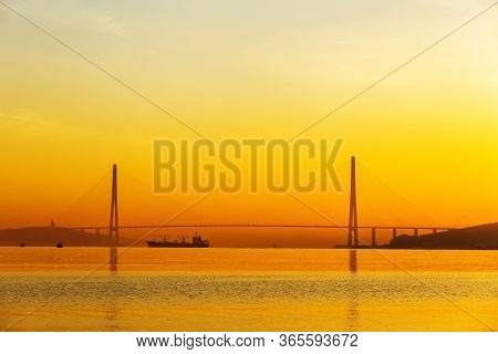 Dawn In The Sea City Of Vladivostok. Cable-stayed Russian Bridge Over Vostochny Bosphorus Strait To 