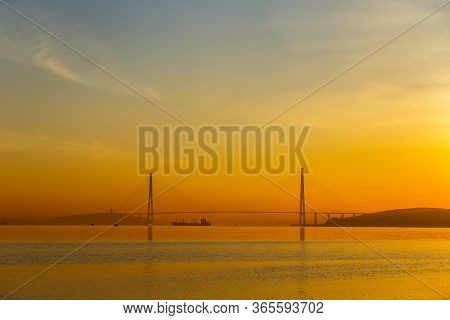 Dawn In The Sea City Of Vladivostok. Cable-stayed Russian Bridge Over Vostochny Bosphorus Strait To 