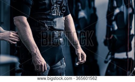 Closeup Of Coach Dressing Man In Electro Muscular Stimulation Vest