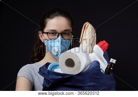 Young Woman In A Valve Of The Respiratory Protective Mask With A Bag Full Of Groceries From The Supe