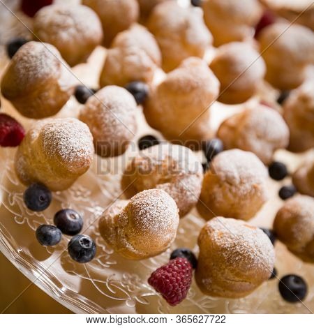 Top View On Delicious Profiteroles With Vanilla Cream And Icing Sugar. Profiteroles Are Decorated Wi