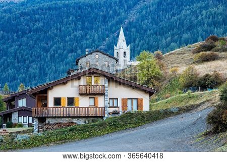 Alpine Landscape Of The French Alps, Lanslevillard With St. Michaels Church In The Provence Alpes, F