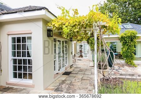 Patio Terrace Of Upmarket Wealthy Suburban Mansion House With Landscaped Garden