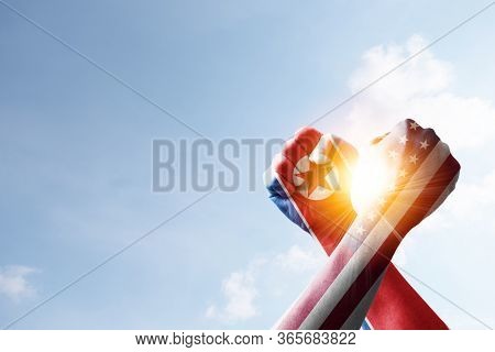 Usa Flag And North Korea Flag Print Screen Fists And Wrestling With Blue Sky And Sunlight. United St