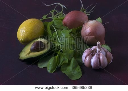 An Avocado With A Lemon, Garlic, Onions And Arugula