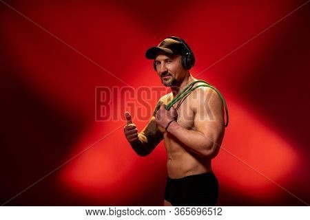 Athletic Man With Naked Torso And Tattoo On Red Background. Advertising Fitness Trainer Shows Class 