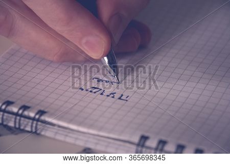 Closeup Of A Man Handwriting The Aramaic Alphabet In A Notepad. The Aramaic Alphabet Is Historically