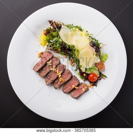 Grilled Roast Beef Salad Served With Arugula And Parmesan Cheese