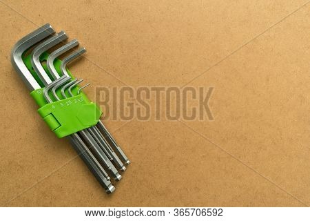 Set Of Hex Wrenches On Plywood Background. Copy Space.