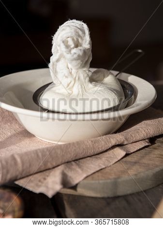 Preparation Of Cottage Cheese - Woman Straining The Milk Through A Cheesecloth. Preparation Of Cotta