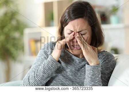 Middle Age Woman Suffering Eyestrain Sitting On A Couch At Home