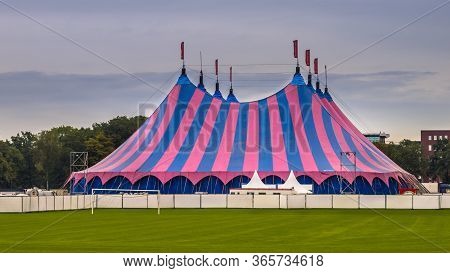 Circus Tent With Pink And Blue Striped On Green Lawn Under Summer Sky. Venue Accomodation Used On Su
