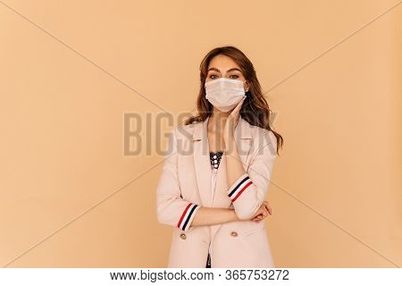 Porttrait Of A Young Beautiful Businesswoman Wearing Medical Mask On Yellow Background