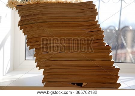 Old News Magazines Are Lying On A Windowsill Like A Tower.