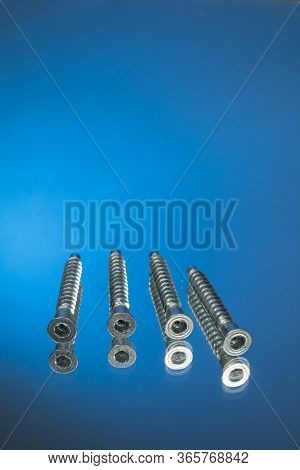 Countersunk Wood Screws On A Blue Background.